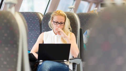 Vrouw in trein met laptop