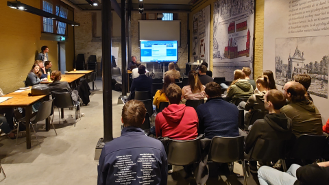 zaal met studenten die luisteren naar verhaal van een ervaringsdeskundige