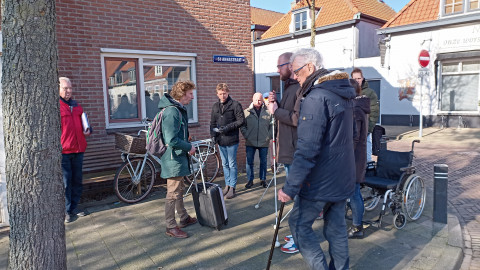 Mensen met taststokken in de hand op een stoep