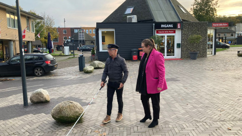 Op een winkelstraat in de gemeente Borger-Odoorn loopt een man met witte stok die wordt vergezeld door een mevrouw