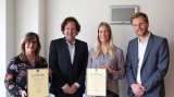wethouder gemeente Woerden George Becht neemt drempelvrij certificaat in ontvangst in aanwezigheid van Connie van Leeuwen en Ilse van der Meer van de gemeenten en Twan van Houtum van Stichting Accessibility