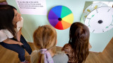 Drei personen kijken naar een kleurencirkel