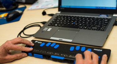 Blinde computergebruiker - handen op brailletoetsenbord