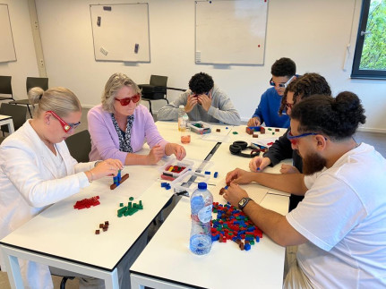 Studenten aan tafel met lego tijdens workshop
