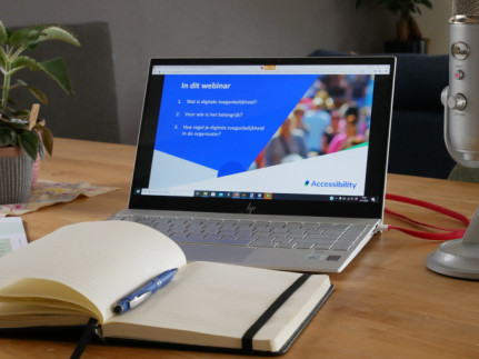 Laptop met daarnaast microfoon en daarvoor notitieblok. Bij de alinea Zo helpt Stichting Accessibility - jouw praktische brug naar participatie
