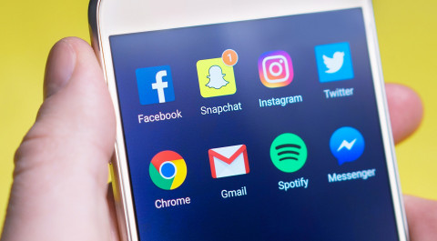 Close up van een smartphone met daarop de pictorgrammen van social media en andere apps
