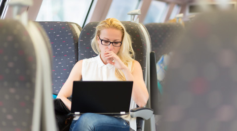Vrouw in trein met laptop