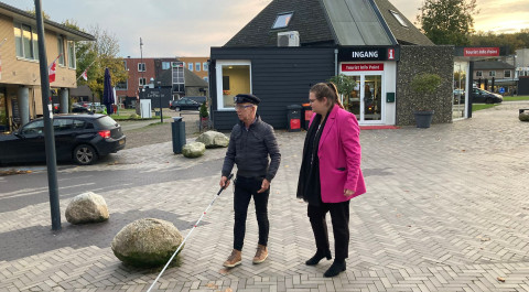 Op een winkelstraat in de gemeente Borger-Odoorn loopt een man met witte stok die wordt vergezeld door een mevrouw